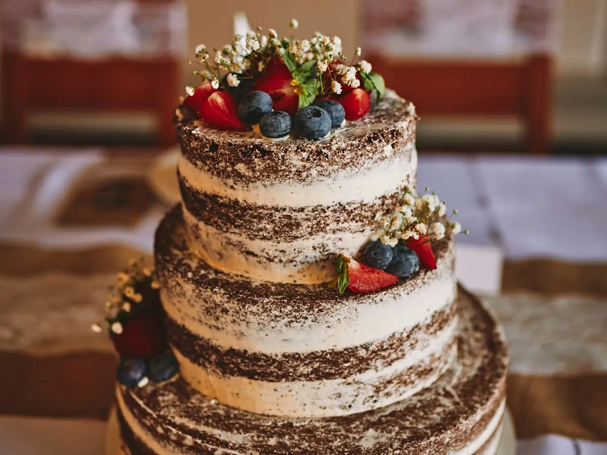 A celebration cake decorated with berries and flowers